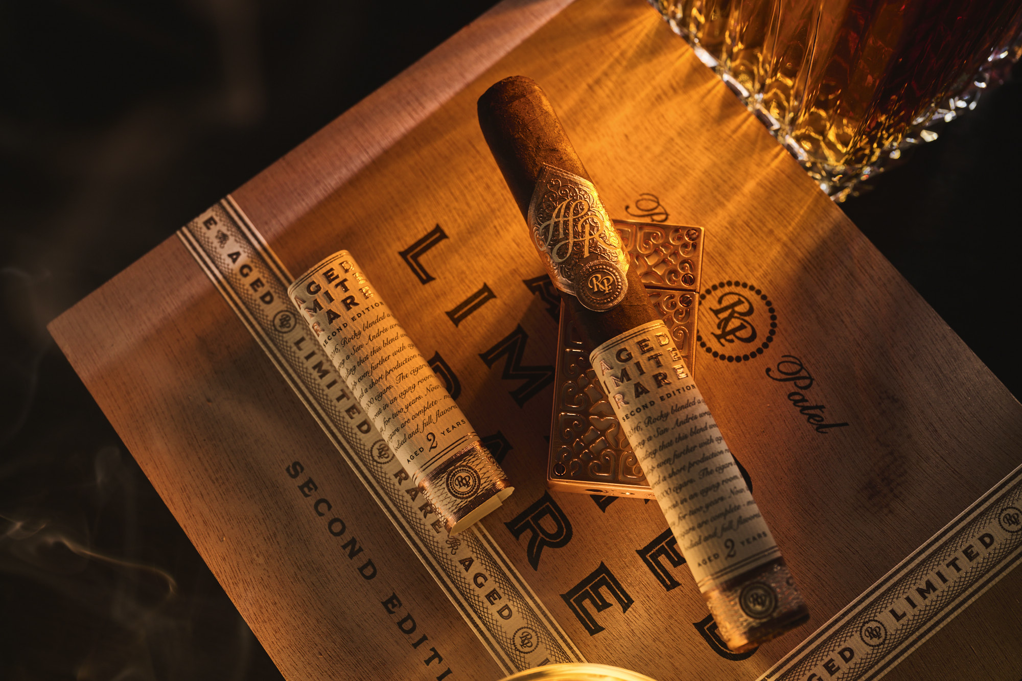 A wooden Limited Edition cigar box, with aged cigars and gold-foil labels in warm light.